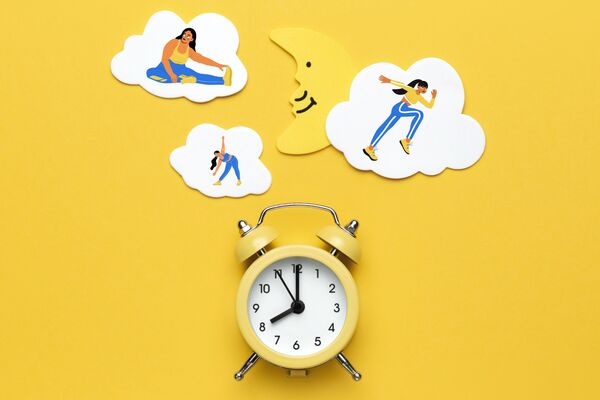 un réveil-matin avec des nuages au dessus dans lesquels apparaissent des personnages en train de faire du sport.