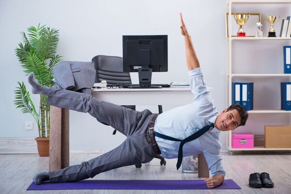 un jeune cadre fait du sport dans son bureau
