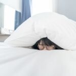 une femme se cache sous sa couette