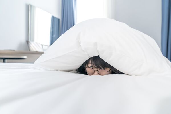 une femme se cache sous sa couette