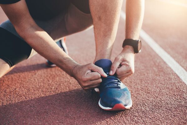 un sportif attache ses chaussures de sport